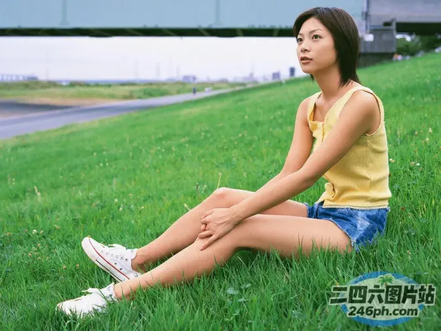 穿着黄色衬衫坐在草地上的阿拉夫德女人