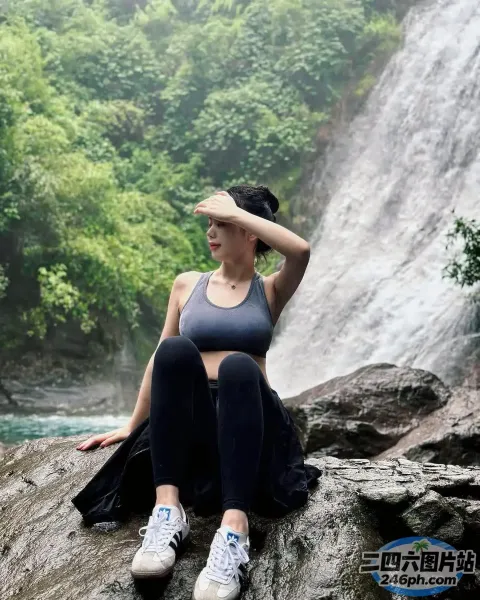 坐在瀑布前岩石上的阿拉夫德女人