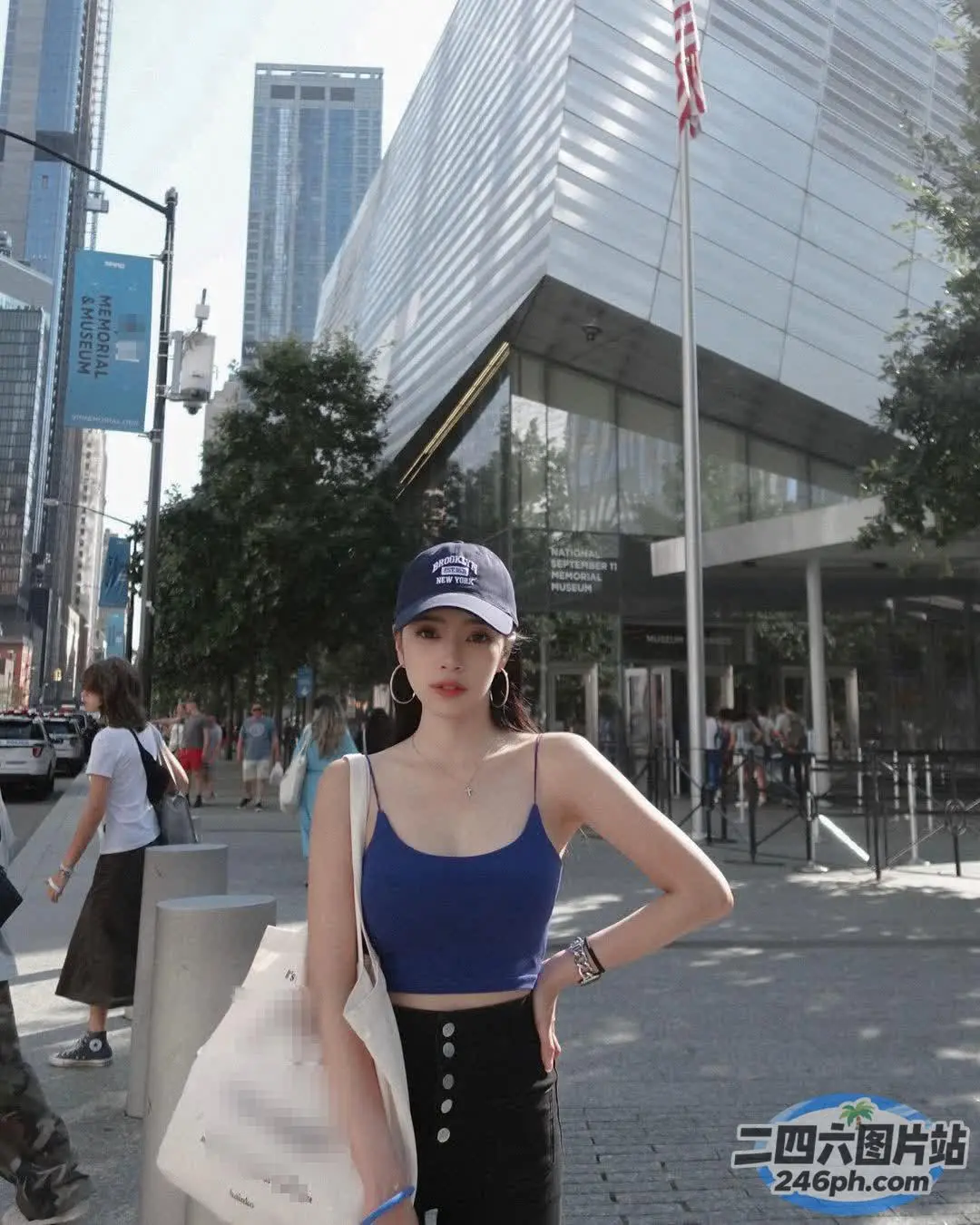 身穿蓝色上衣和黑色裤子的 Araffe 女子站在人行道上