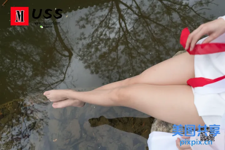 水边的一块岩石上坐着一个穿着白色连衣裙的女人