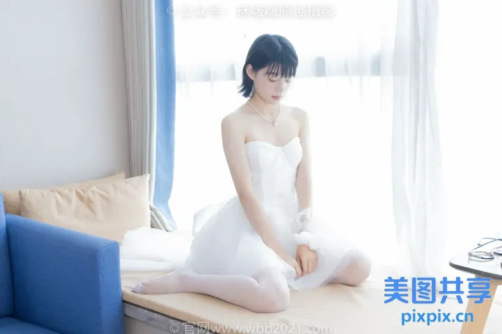 床上坐着一个穿着白色连衣裙的女人