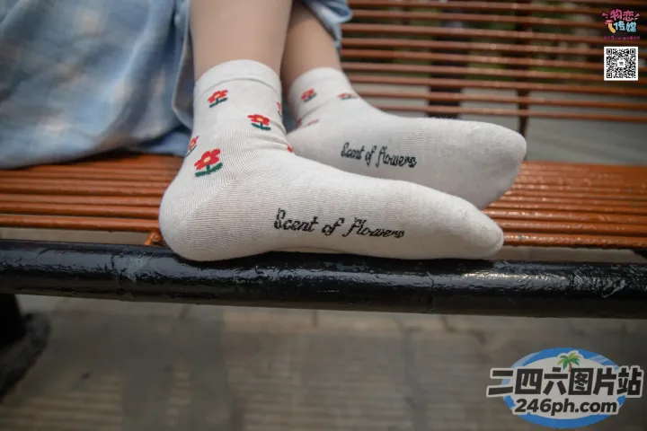 有人坐在长凳上，脚抬起来，穿着袜子