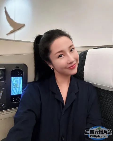 坐在飞机座位上拿着手机的女人