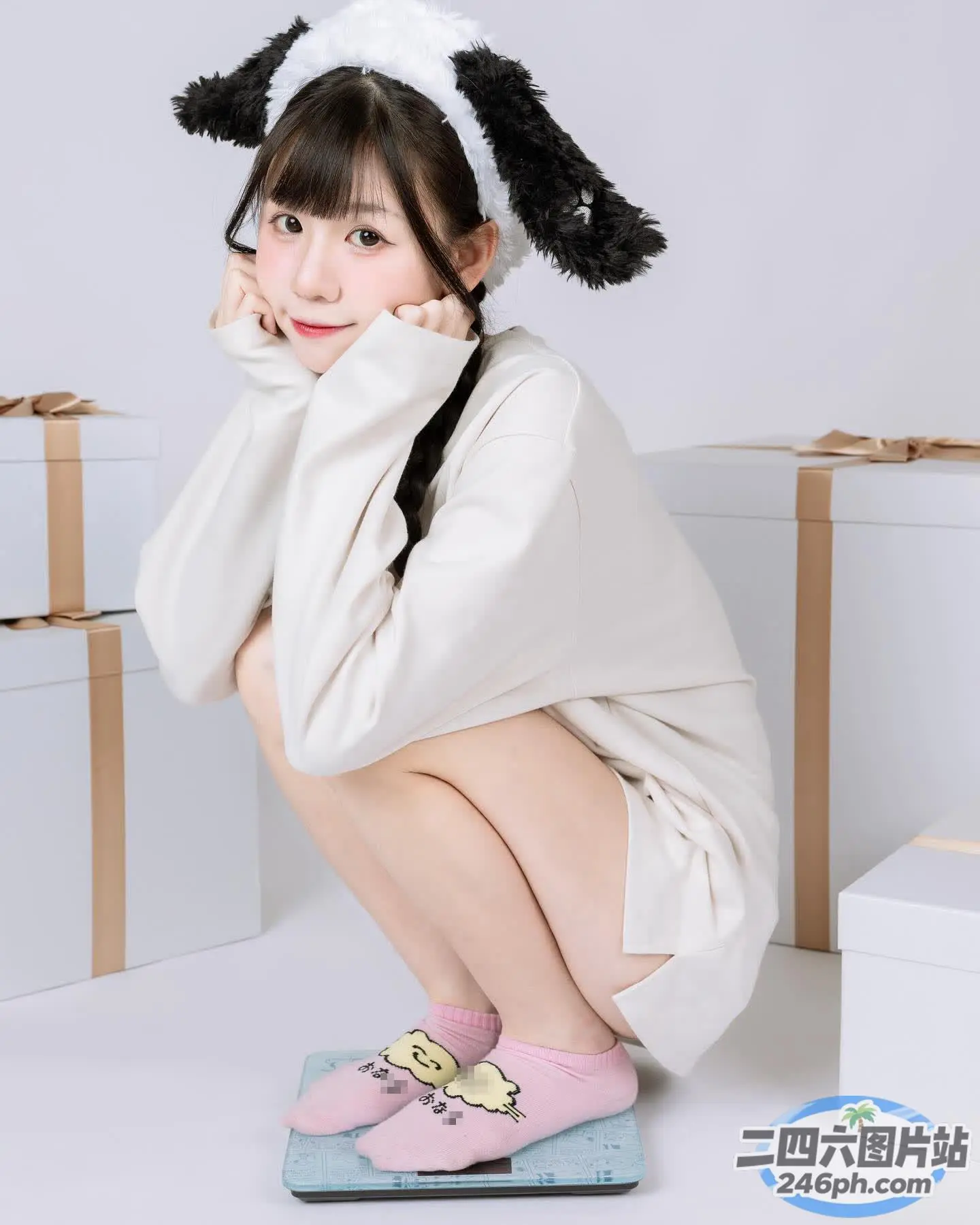 身穿白色连衣裙和粉红色鞋子的 araffe 女孩坐在秤上