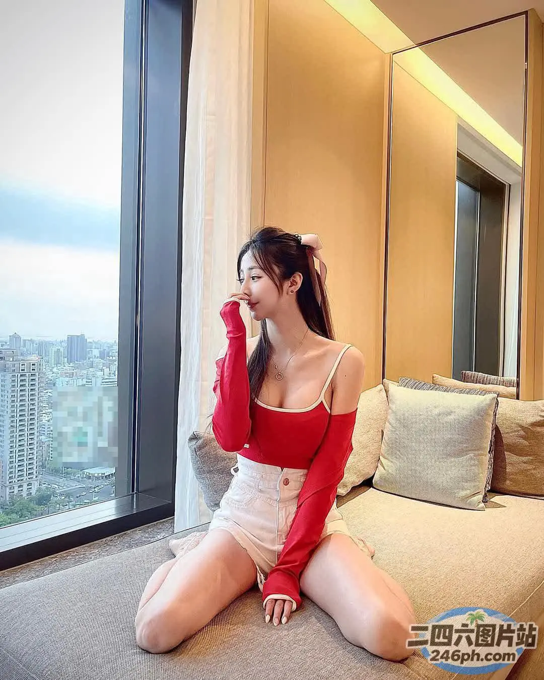 Araffe 女人坐在一个有大窗户的房间的沙发上
