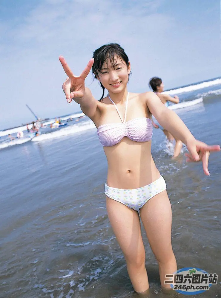 身穿比基尼的 araffe 女子在海滩上做和平标志