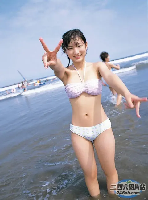 身穿比基尼的 araffe 女子在海滩上做和平标志