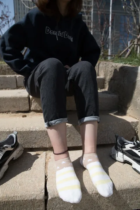 阿拉夫德女人坐在台阶上，脚踩着一双鞋