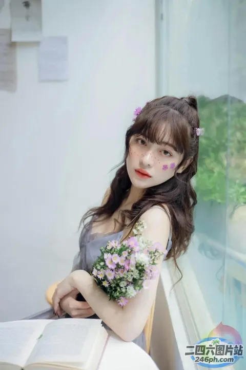 阿拉夫德女人坐在桌子旁，手里拿着一本书和鲜花