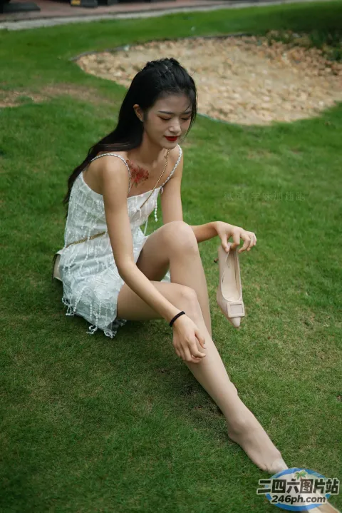 穿着鞋子坐在草地上的阿拉菲女人