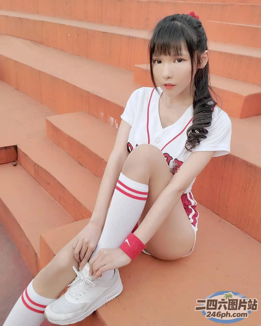 穿着白衬衫和红白袜子系鞋带的亚洲女孩