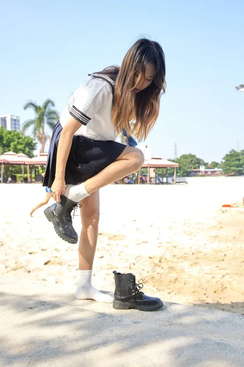 海滩上有个女人弯腰捡鞋