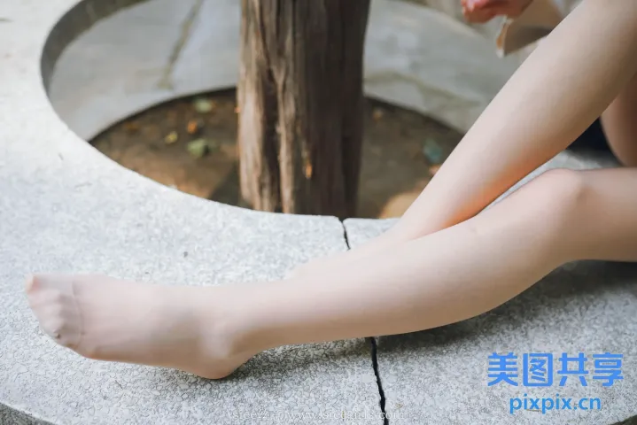 有一个女人盘着腿坐在长凳上