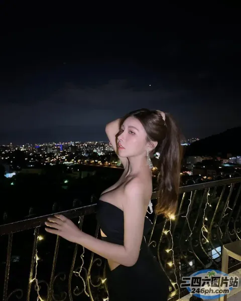 晚上站在阳台上的黑裙 araffe 女人