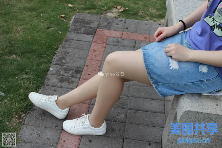 双腿交叉坐在长凳上的阿拉菲德女人