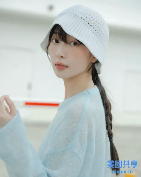 戴白帽子和蓝色毛衣的 arafed 亚洲女性