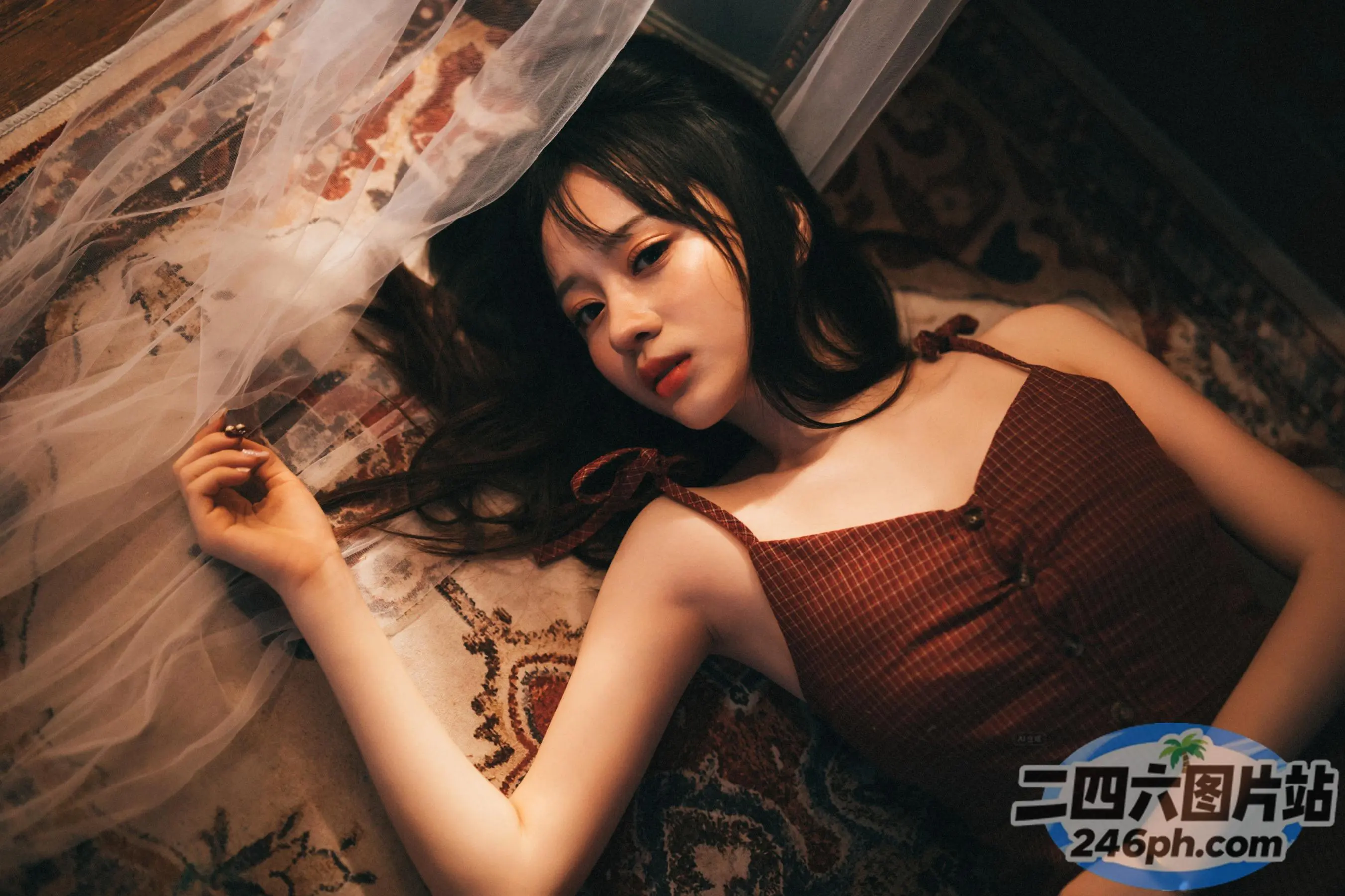 有一个女人躺在床上，头上蒙着面纱