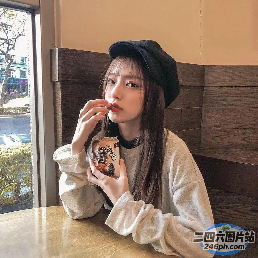 有个女人坐在桌子旁吃甜甜圈