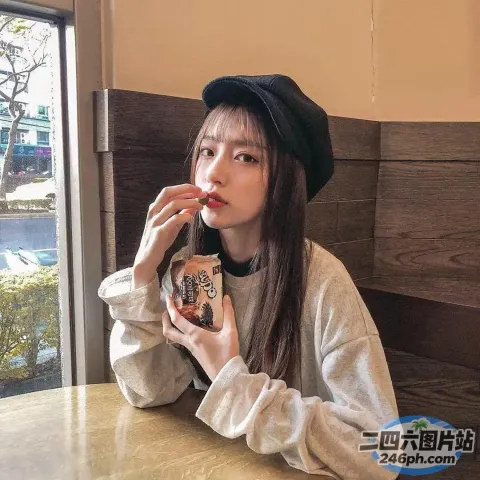 有个女人坐在桌子旁吃甜甜圈