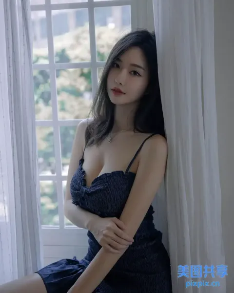 一个穿着蓝色连衣裙的女人坐在窗台上