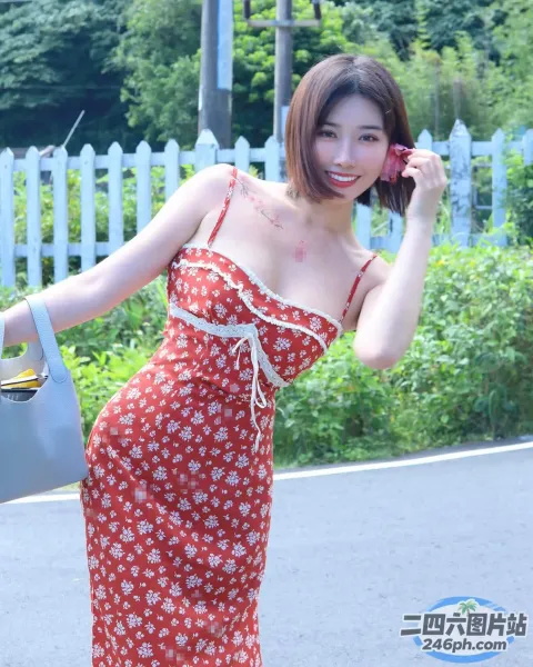 红裙女子走在街上时用手机说话