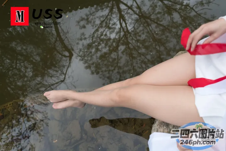 水边的一块岩石上坐着一个穿着白色连衣裙的女人