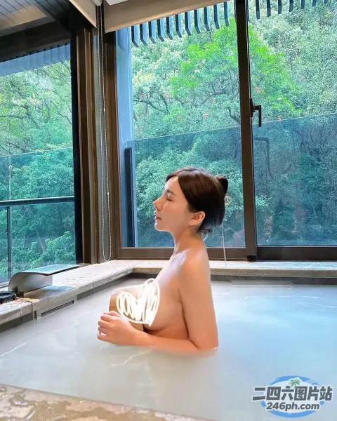 有个女人坐在浴缸里，身上缠着毛巾