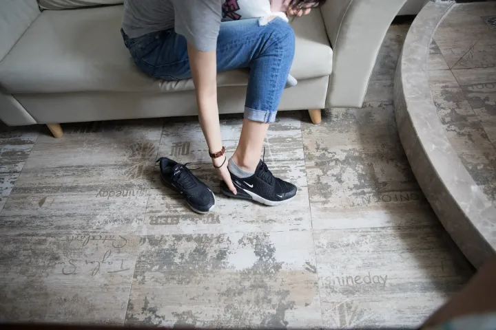 有一个女人坐在沙发上系鞋带