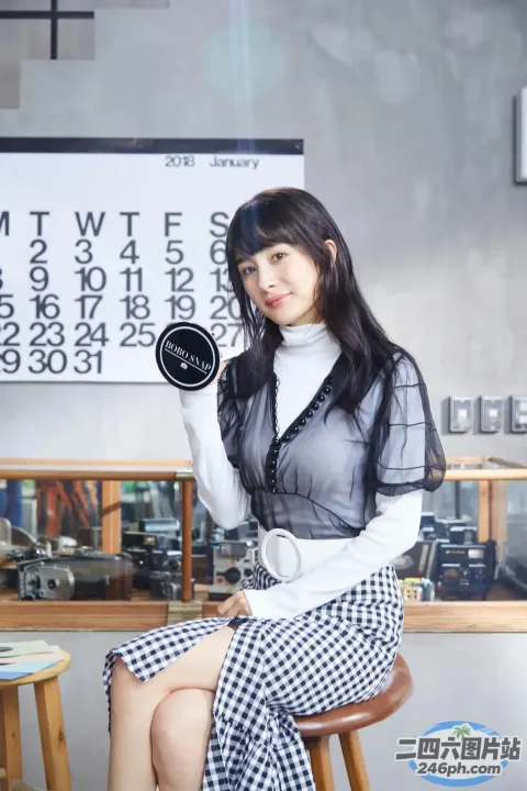 有一个女人坐在凳子上，手里拿着一个钟