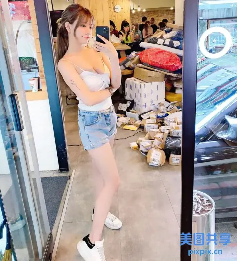 有个女人站在商店里看手机