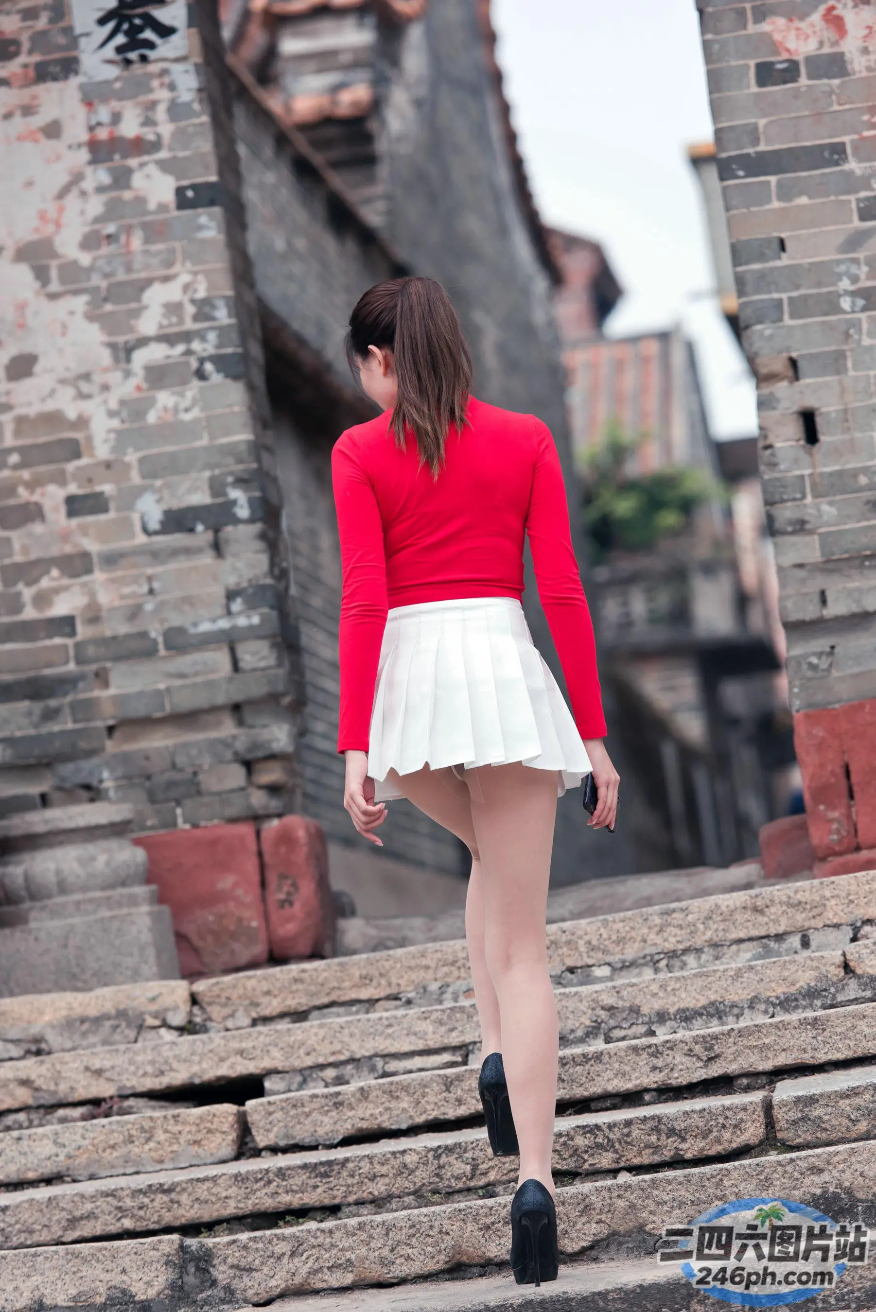 穿着红白裙子的 arafed 女人走上楼梯