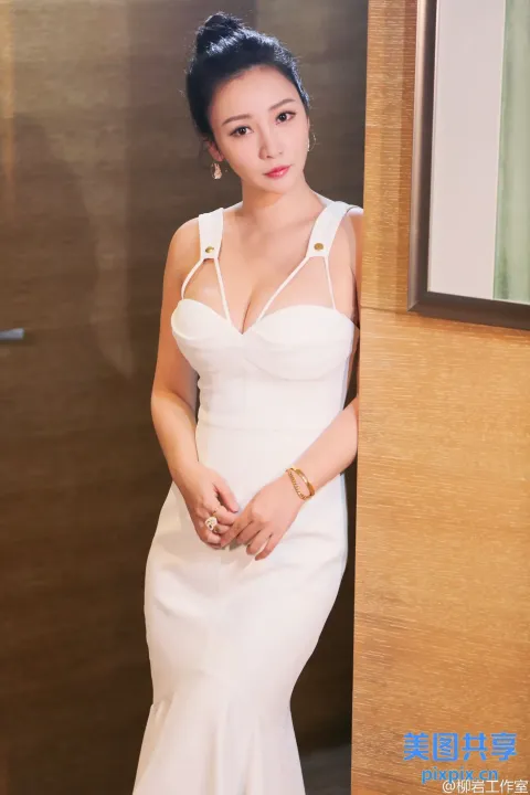 身穿白色连衣裙靠在墙上的阿拉夫女人
