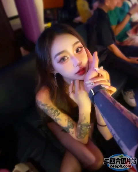 有个女人坐在沙发上，胳膊上有纹身