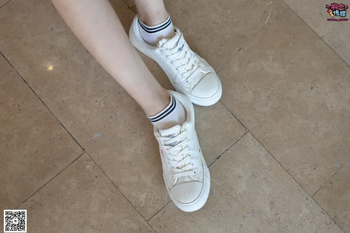 有一个女人穿着鞋子站在瓷砖地板上