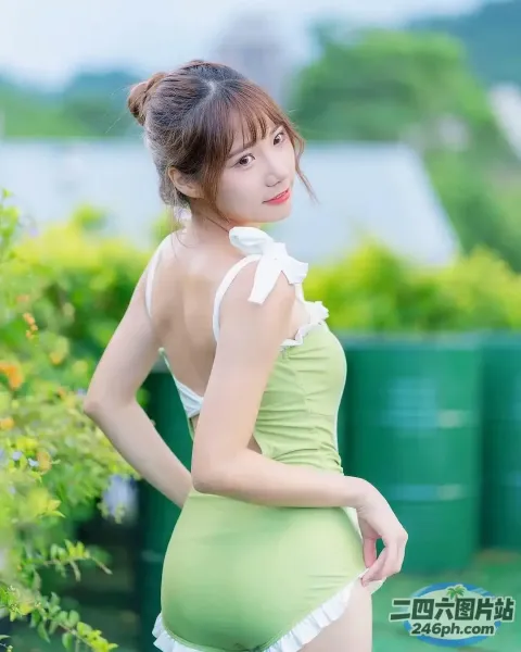 一位身穿绿色连衣裙的女子摆姿势拍照的特写