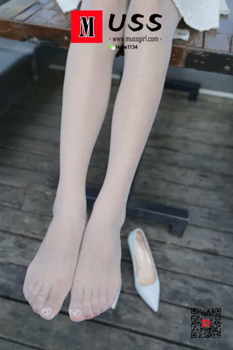 有个女人坐在长凳上，双脚抬起