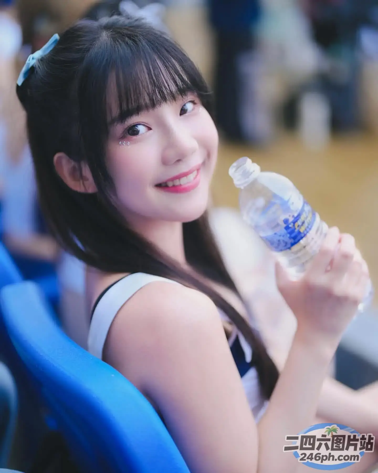 Araffe 女孩在体育场内举着一瓶水