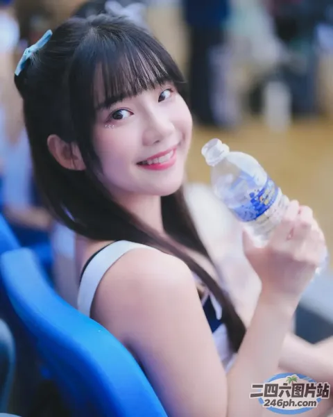 Araffe 女孩在体育场内举着一瓶水