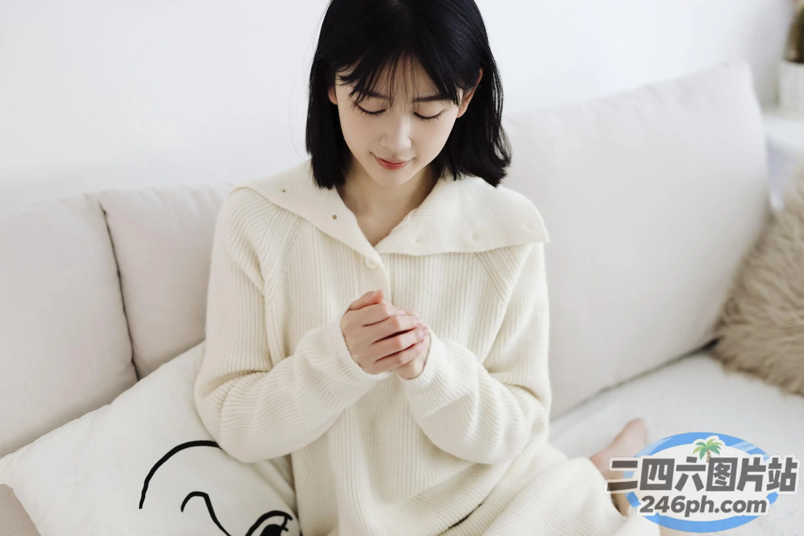 拿着枕头和枕头坐在沙发上的阿拉菲女人