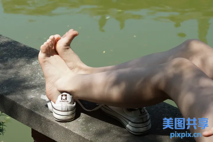 有人坐在壁架上，双脚抬起，穿着鞋子