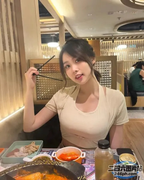 女人坐在桌子旁，手里拿着一碗食物和一把叉子