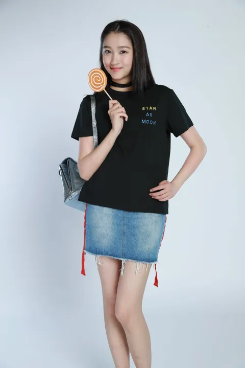 身穿黑色衬衫和牛仔裙的阿拉夫女人拿着棒棒糖