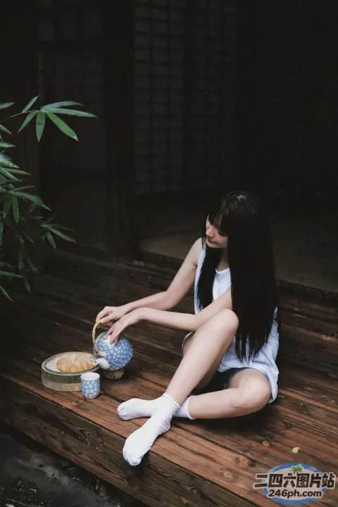 阿拉菲女人坐在木制门廊上，手里拿着茶壶和碗