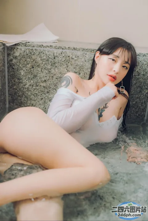 Araffe 亚洲妇女在浴缸里，手臂上有纹身