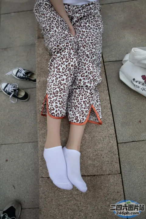 有个女人坐在长凳上，双脚抬起