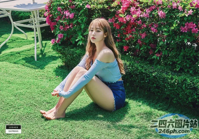Araffe 坐在开满鲜花的灌木丛前的草地上