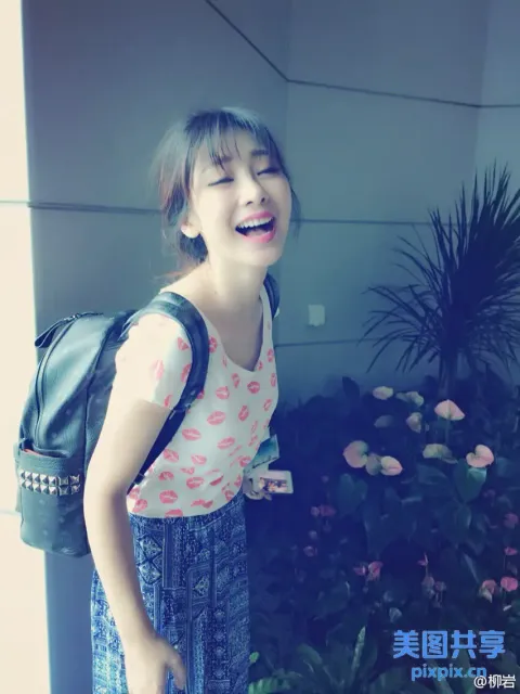 背着背包在花园前大笑的阿拉菲德女孩