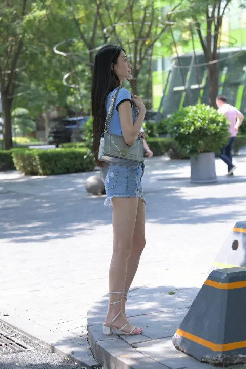 站在人行道上的阿拉菲女子正在用手机说话