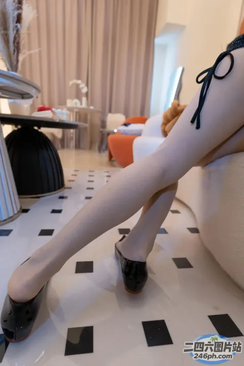 瓷砖地板上一位穿着高跟鞋的女人的双腿特写