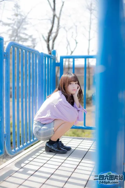蹲在公园游乐场长椅上的 arafed 女孩